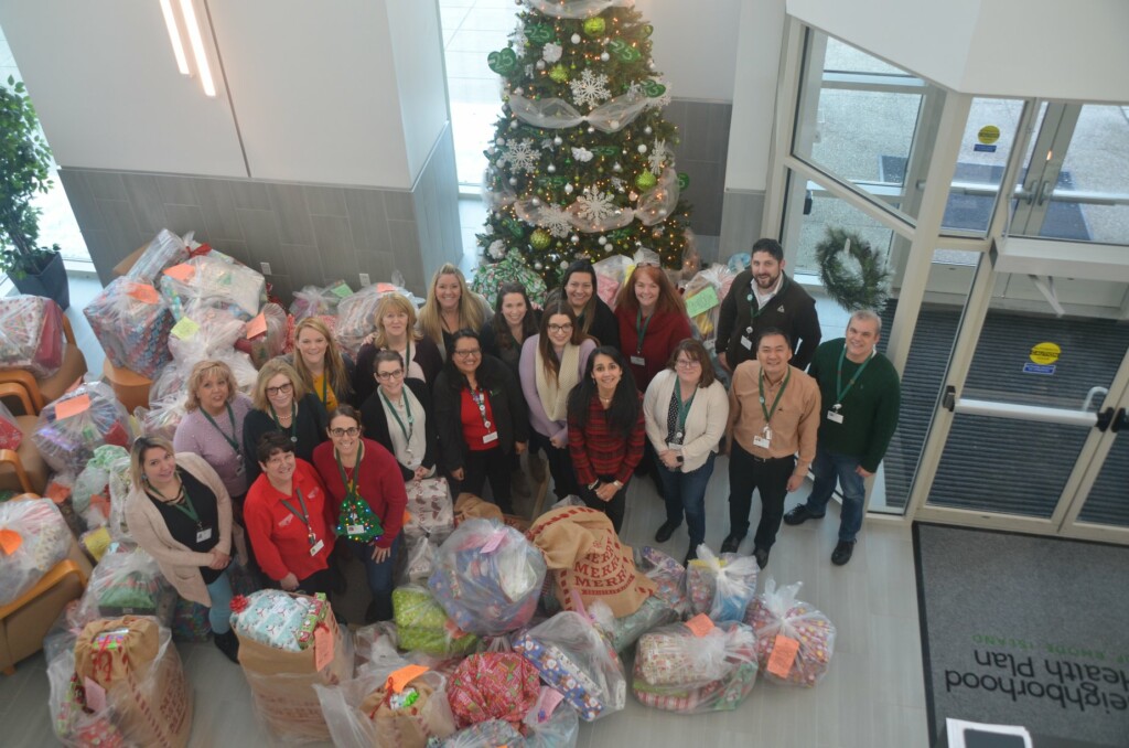 Employees posing with donated christmas gifts